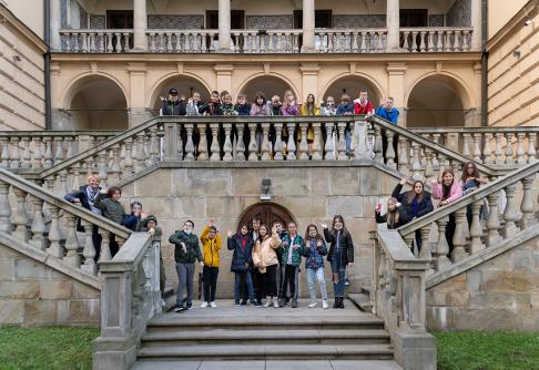 Na zdjęciu dzieci - uczestnicy programu dukaty Decjusza stoją na schodach Willi Decjusza.